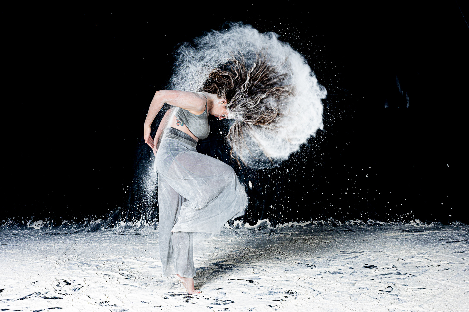 Creative powder dance portrait against a black backdrop